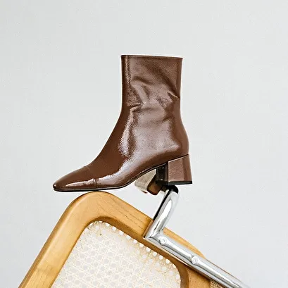 Square-toed boots with small heels in brown pleated patent