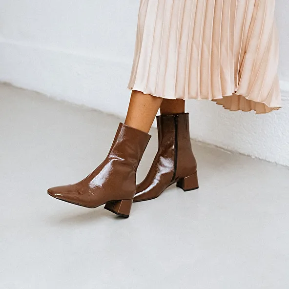 Square-toed boots with small heels in brown pleated patent